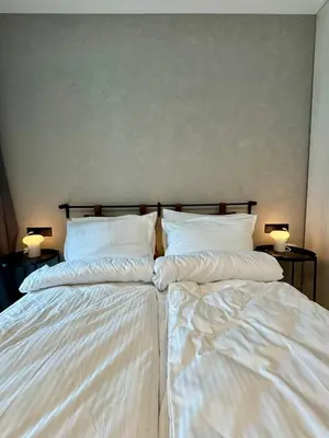 two beds in a room with white sheets and lamps at Eleve Residences - Stone Studios in Sofia