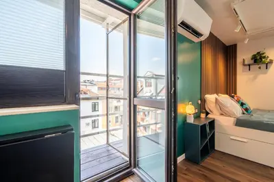 a room with a large window and a bed and a balcony at Leafy Loft in Sofia