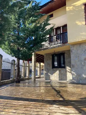 a building with a tree in front of it at Къща за гости Рупчос 1 in Smolyan