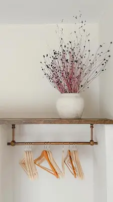 a shelf with a vase on it with hangers at Stylish Retreat in Sofia in Sofia
