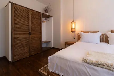 a bedroom with a white bed and a wooden closet at Stylish Retreat in Sofia in Sofia