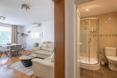 a bathroom with a shower and a living room at Spacious 1 bedroom apartment in a lively center in Sofia