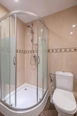 a bathroom with a shower and a toilet and a tub at Spacious 1 bedroom apartment in a lively center in Sofia