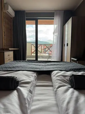 a large bed in a room with a large window at VeliApartmets in Velingrad