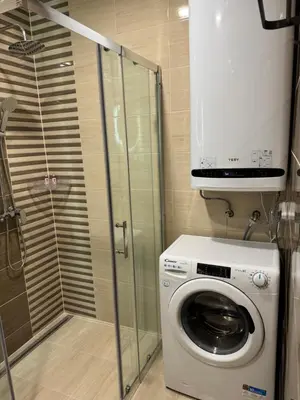 a washing machine in a bathroom with a shower at VeliApartmets in Velingrad