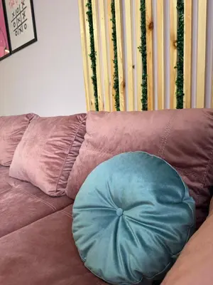 a blue pillow sitting on top of a brown couch at VeliApartmets in Velingrad
