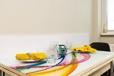 a table with plates and glasses on top of it at 1BD Flat in Plovdiv - 25 min Walk from the Centre by Flat Mаnаger in Plovdiv
