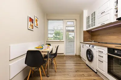 a small kitchen with a table and a washer and dryer at 1BD Flat in Plovdiv - 25 min Walk from the Centre by Flat Mаnаger in Plovdiv