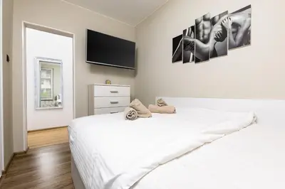 a bedroom with a white bed and a tv on the wall at 1BD Flat in Plovdiv - 25 min Walk from the Centre by Flat Mаnаger in Plovdiv