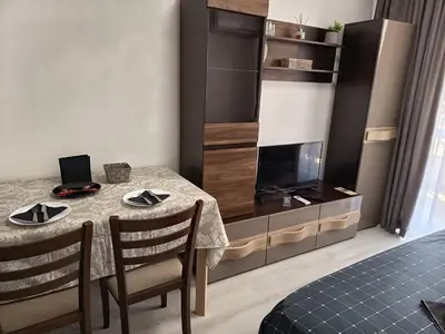 a dining room with a table and a tv at Hotel Rooms St Paul in Plovdiv
