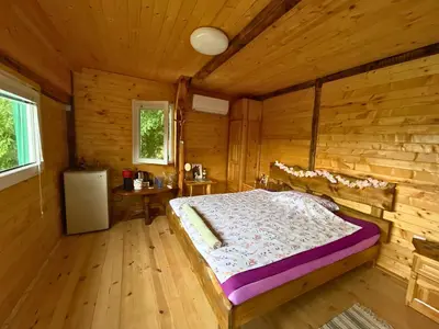 a bedroom with a bed in a wooden cabin at Kъщичка в полите на планина Витоша с коне и животни in Sofia