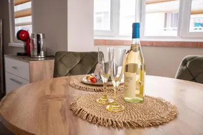 a bottle of wine and two glasses on a table at Center and Old Town Apartment in Plovdiv