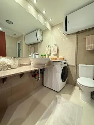 a bathroom with a sink and a washing machine at Downtown Bansko Luxury Resort in Bansko