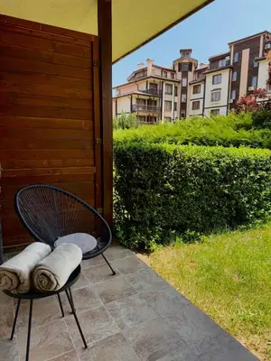 a chair with pillows sitting on a patio at Downtown Bansko Luxury Resort in Bansko