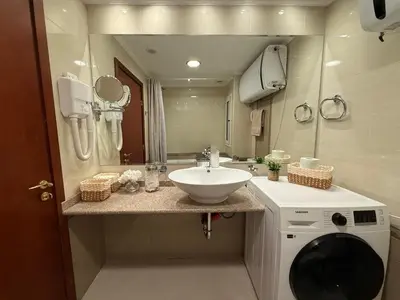 a bathroom with a sink and a washing machine at Downtown Bansko Luxury Resort in Bansko