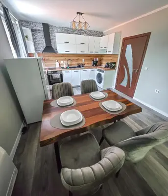 a dining room table with chairs and a kitchen at Апартамент Петя 2 in Velingrad