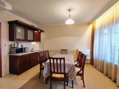 a kitchen and dining room with a table and a microwave at 3 Rooms Apartment next to the Ski lift in Bansko