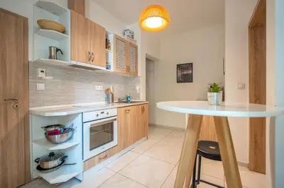 a kitchen with a white counter top and a table at Central Sofia Gem by Vitoshka Street in Sofia