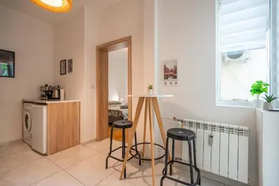 a kitchen with stools in a room with a refrigerator at Central Sofia Gem by Vitoshka Street in Sofia