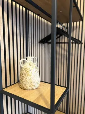 a bird cage with a jug sitting on a shelf at Kolev Apartment in Sofia