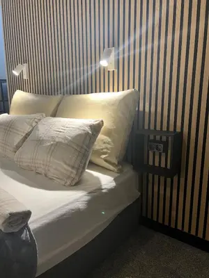 a bed with white pillows and a striped wall at Kolev Apartment in Sofia
