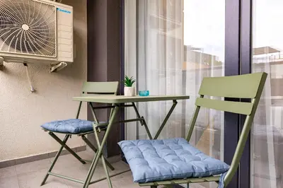 two chairs and a table and a fan in a room at Casa Moderna - Stylish 1BD in South Plovdiv by Flat Manager in Plovdiv