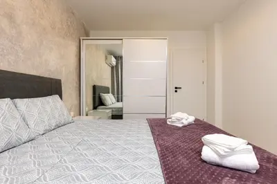a bedroom with a bed with white towels on it at Casa Moderna - Stylish 1BD in South Plovdiv by Flat Manager in Plovdiv