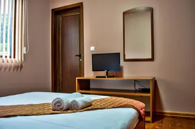 a bedroom with a bed and a desk with a television at Yoneda Houses in Sapareva Banya