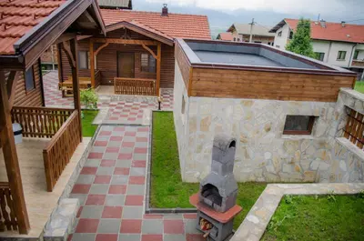 a stone oven in a yard next to a house at Yoneda Houses in Sapareva Banya