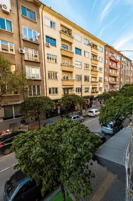 a large building with cars parked in a parking lot at Charming Central Retreat! in Sofia