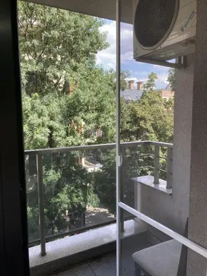 a balcony with a view of a tree at Kyluks 1BR Apartment in Sofia
