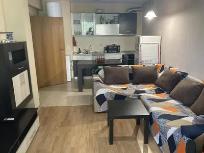 a living room with a couch and a kitchen at Kyluks 1BR Apartment in Sofia