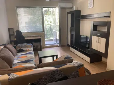 a living room with a couch and a flat screen tv at Kyluks 1BR Apartment in Sofia