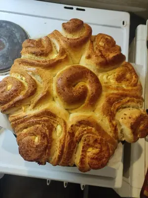 a loaf of bread sitting on a white plate at Кулинарна къща за гости СОФРИЦА in Hvoyna