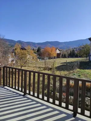 a wooden bridge with a view of a field at Кулинарна къща за гости СОФРИЦА in Hvoyna
