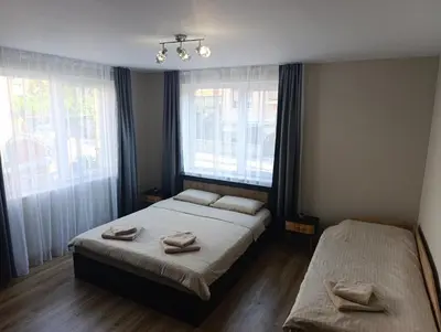 a bedroom with two beds and two windows at Самостоятелен Apartment Emili in Sapareva Banya
