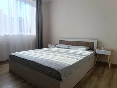 a bedroom with a large bed and a window at Самостоятелен Apartment Emili in Sapareva Banya