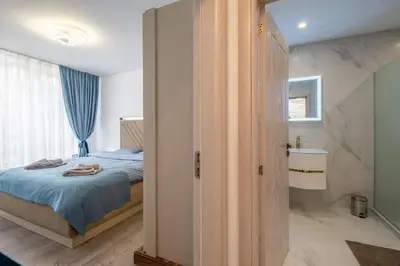 a bedroom with a bed and a bathroom at Elegant Deluxe 2 Bedroom apartment in Sofia