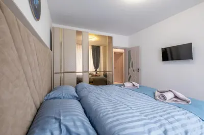 a bedroom with a large bed with blue sheets at Elegant Deluxe 2 Bedroom apartment in Sofia