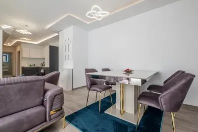 a living room with a table and chairs at Elegant Deluxe 2 Bedroom apartment in Sofia