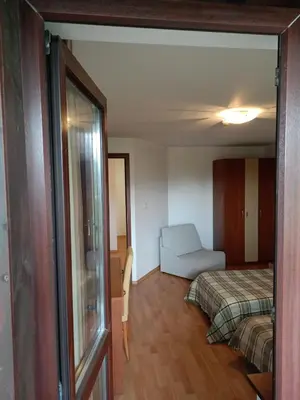 a small bedroom with a bed and a chair at Mountain Paradise 1 - 2 Bedroom - Large apartment in Bansko