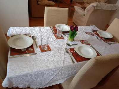 a table with plates and glasses and flowers on it at Mountain Paradise 1 - 2 Bedroom - Large apartment in Bansko