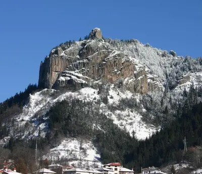 a mountain covered in snow with houses on it at Апартамент ДАРА in Smolyan