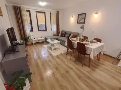 a living room with a table and a couch at Апартамент ДАРА in Smolyan