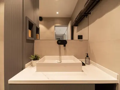 a bathroom with a white sink and a mirror at APEX Apartments Sofia - MountainView in Sofia