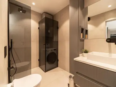a bathroom with a sink and a washing machine at APEX Apartments Sofia - MountainView in Sofia
