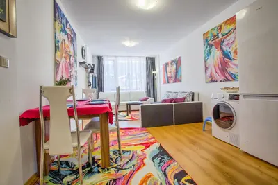 a living room with a table and a washing machine at Mountain view apartment in Aspen Golf Resort with SPA in Bansko