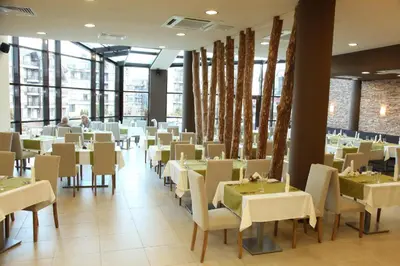 a dining room with white tables and chairs at Mountain view apartment in Aspen Golf Resort with SPA in Bansko