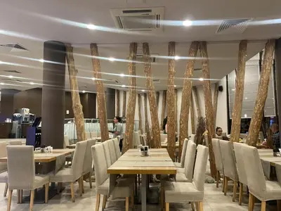 a restaurant with tables and chairs and people in the background at Mountain view apartment in Aspen Golf Resort with SPA in Bansko