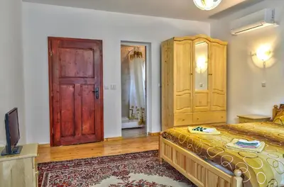 a bedroom with a bed and a wooden door at Guest House JoJi in Sapareva Banya